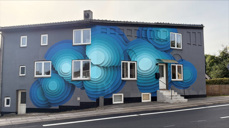 Gavlmalleriet i Hovedgård er malet af kunstneren 1010 og forestiller store tre-dimensionelle cirkler i nuancer af blå.